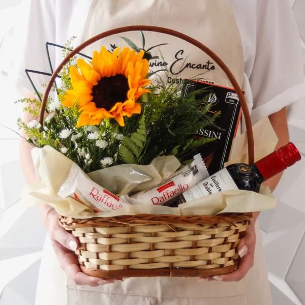 Cesta de presente com vinho, arranjo de girassol, vinho e palitos de parmesão