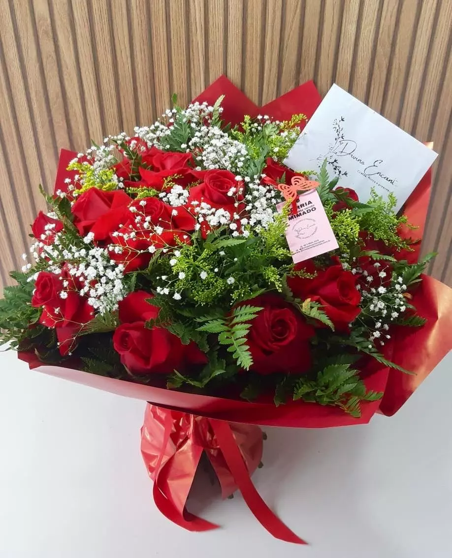 Buque com 12 rosas Buquê com 12 rosas vermelhas com gipsofila branca e folhagens verdes, embalado em papel vermelho com laço decorativo