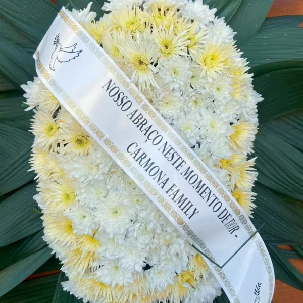 Coroa de flores fúnebre branca e amarela com faixa de condolência personalizada